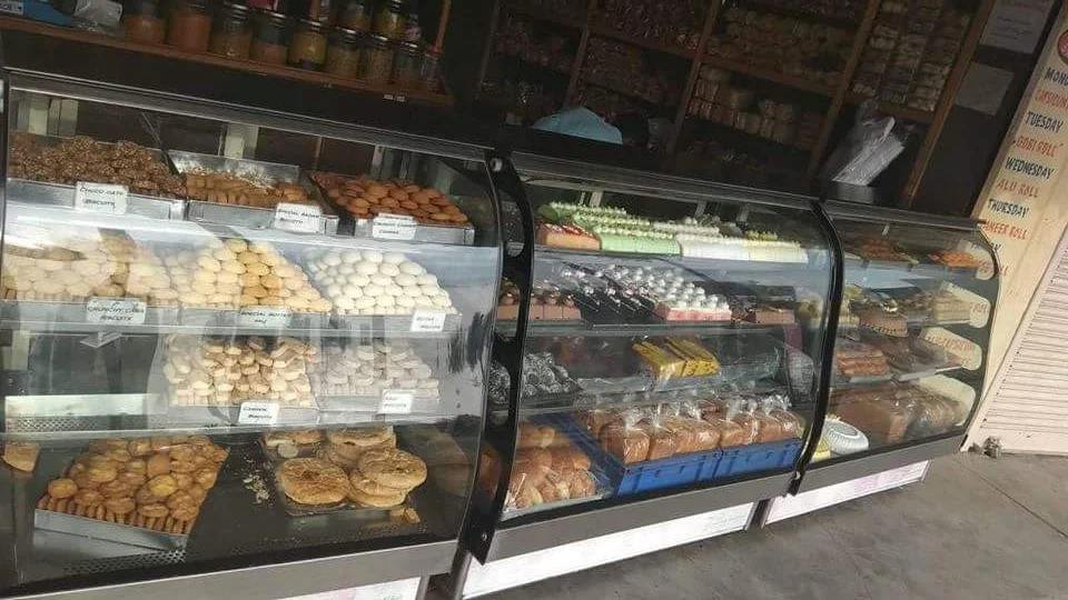 Glass display counters at Sri Venkateshwara Iyengar's Bakery in KR Puram showcasing traditional biscuits, buns, cakes, and bakery snacks