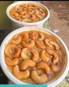 Guvvalacheruvu Palakova topped with roasted cashews in large containers