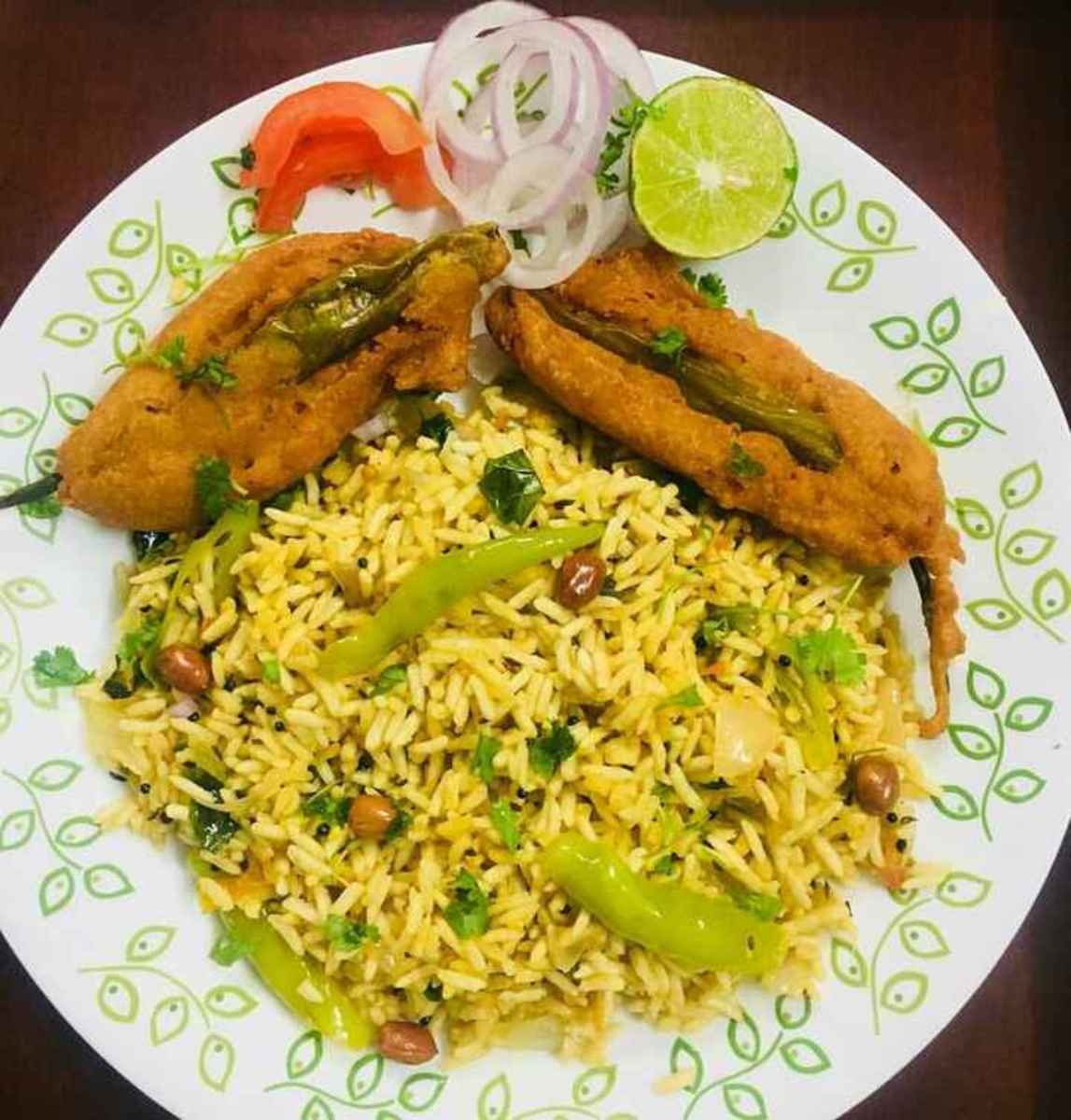 Uggani Bajji Ananthapur style served with mirchi bajji, onions, and lemon on a plate