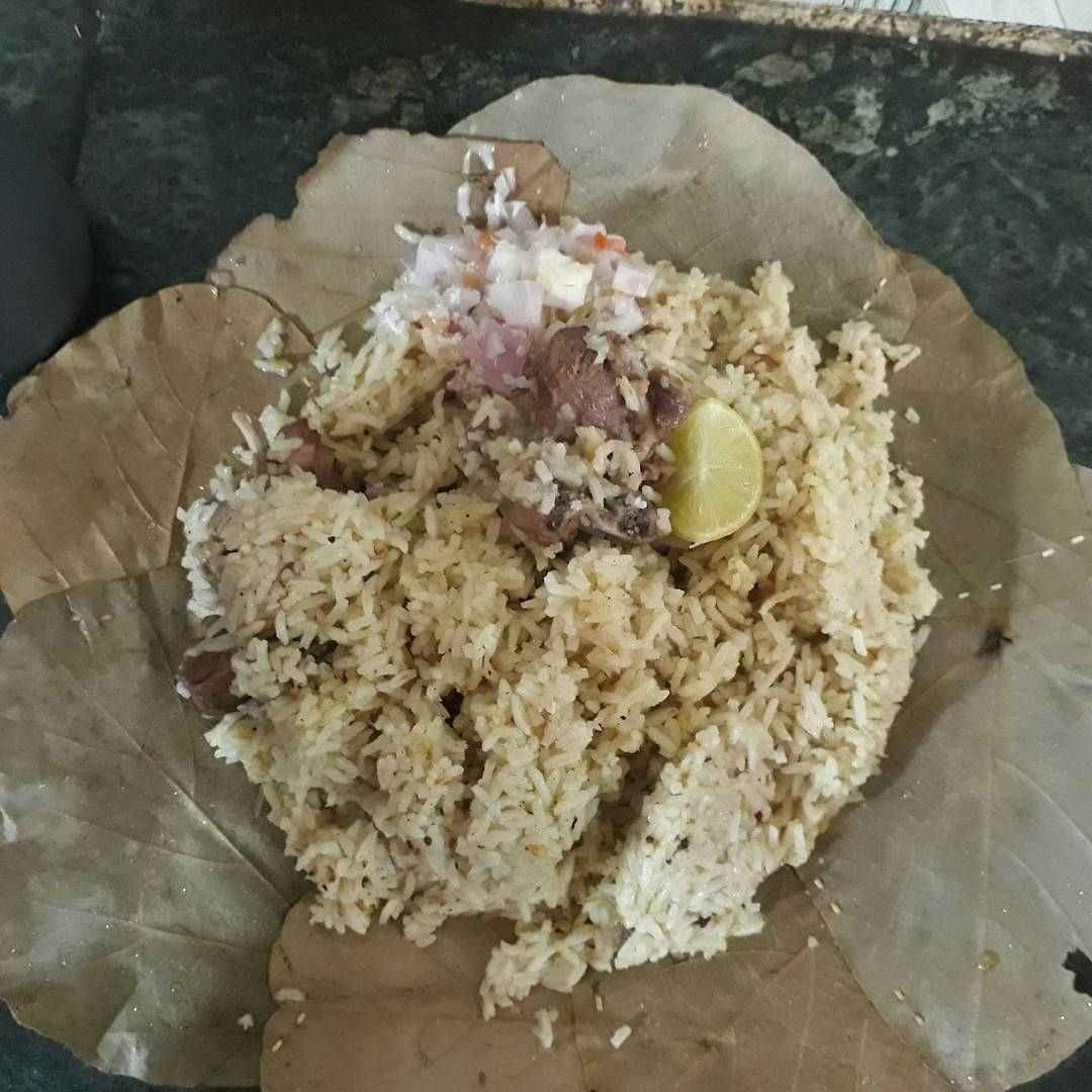 Mutton pulao served on banana leaf at Hotel Hanumanthu Mysuru with chopped onions and lemon slice