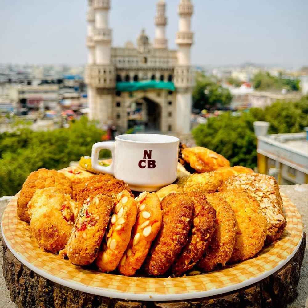 Osmania biscuits and Irani chai at Nimrah Cafe with Charminar in background Hyderabad
