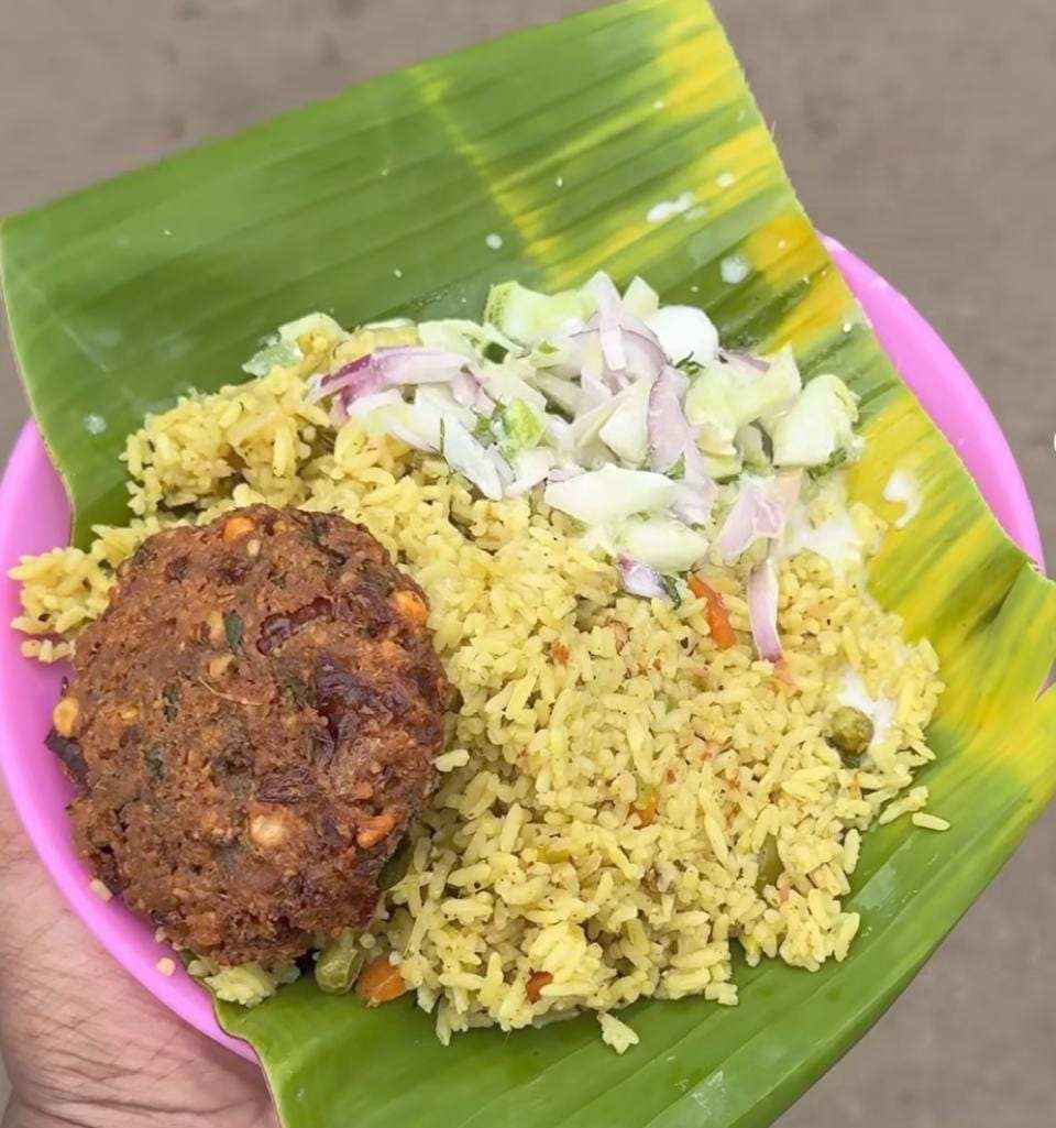 Khara bath rice with vada and onion salad served on banana leaf at Mahesh Hotel.