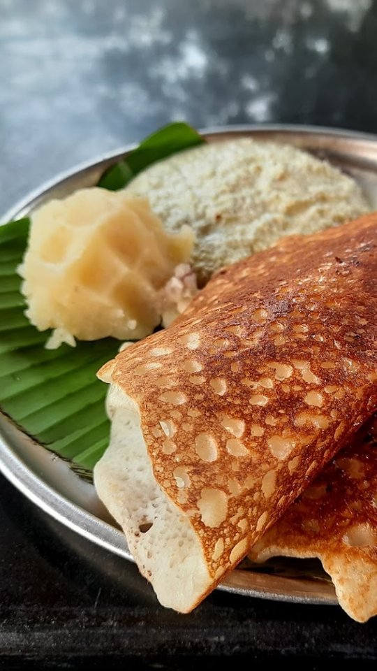 Crispy Karnataka style benne dose served with coconut chutney and butter on banana leaf