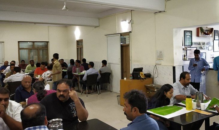 Interior dining area of Shivaji Military Hotel in Bengaluru filled with customers enjoying Donne Biryani and traditional military-style meals.
