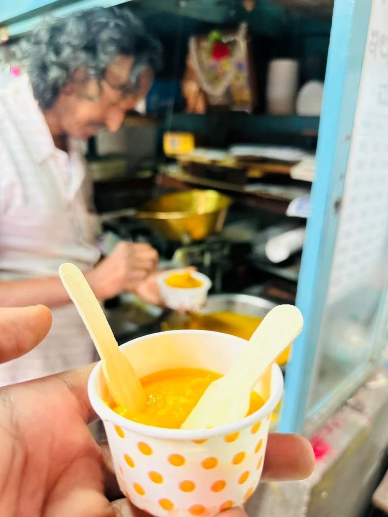 Cup of hot Kollegala Badam Halwa served fresh with pure ghee at the traditional sweet house.