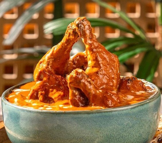 Butter chicken served at Gulati Restaurant Delhi, a famous North Indian dish with rich creamy tomato gravy