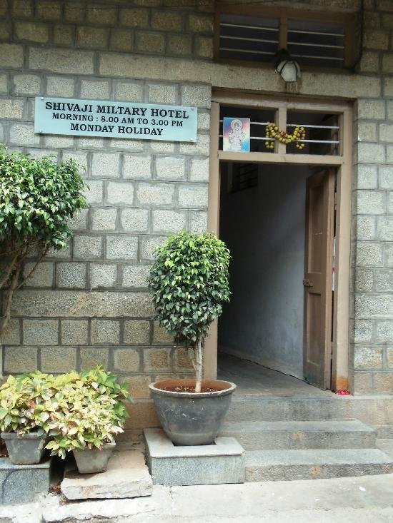 Entrance of Shivaji Military Hotel in Jayanagar Bengaluru with signage showing restaurant timings.