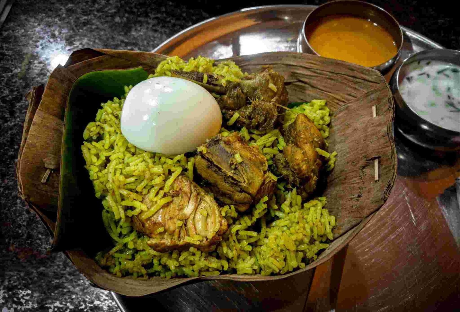 Donne Biryani Bangalore style served in leaf bowl with chicken pieces and boiled egg