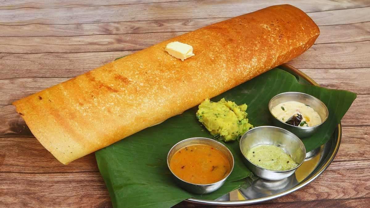 Crispy masala dosa served with chutney and sambar on banana leaf