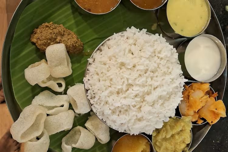 Banana leaf meal at Mami Mess Chennai with rice, sambar, vada and appalam served on a plate