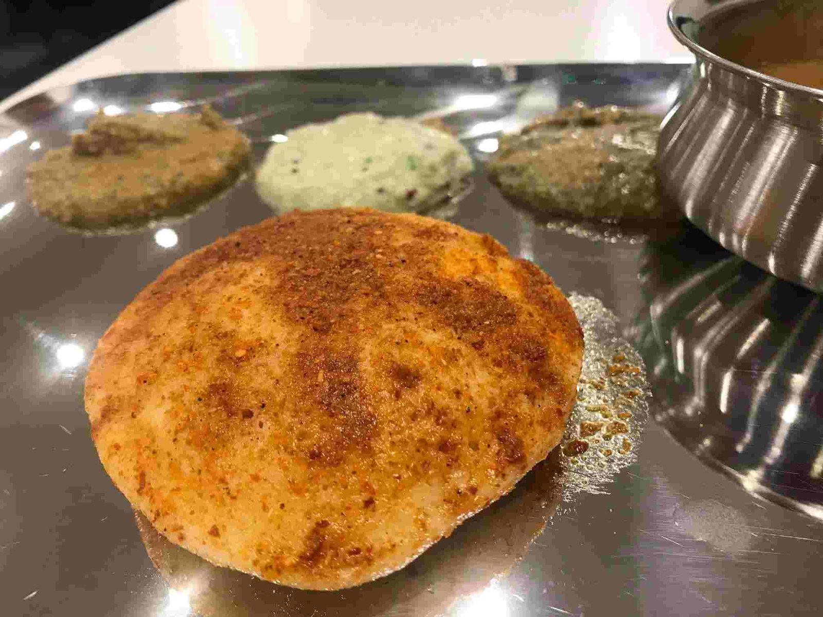 Ghee podi idli served on steel plate with chutneys at Murugan Idli Shop Chennai