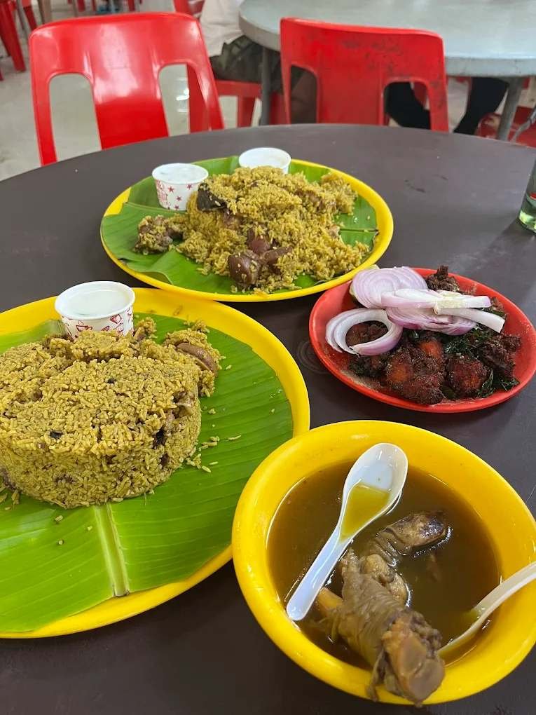 Mutton and chicken dum biryani with paya soup and fried chicken served on banana leaf at Raj Dum Biryani Hoskote