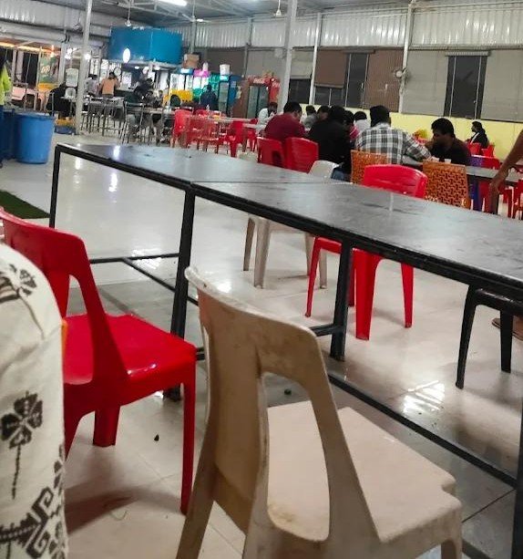 Simple dining area with plastic chairs inside Raj Dum Biryani Hoskote
