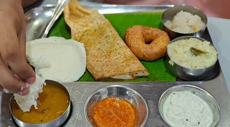 South Indian breakfast plate with idli, dosa, vada, pongal and chutneys served at Ratna Cafe Chennai
