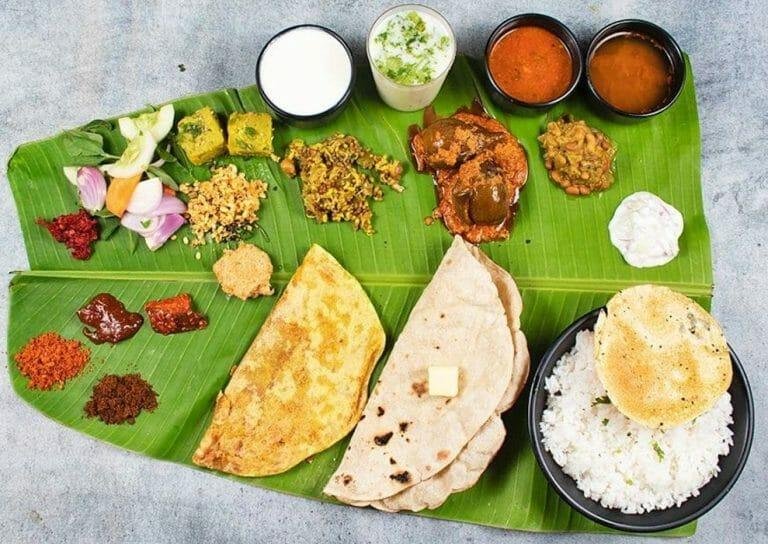 Traditional South Indian thali served on banana leaf with rice, curries, papad and side dishes