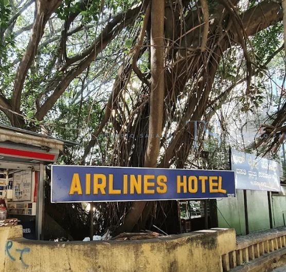 Airlines Hotel Bangalore signboard under large banyan trees on Lavelle Road