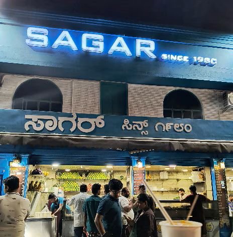Sagar Juice Centre Bangalore night view with customers and bright shop signage