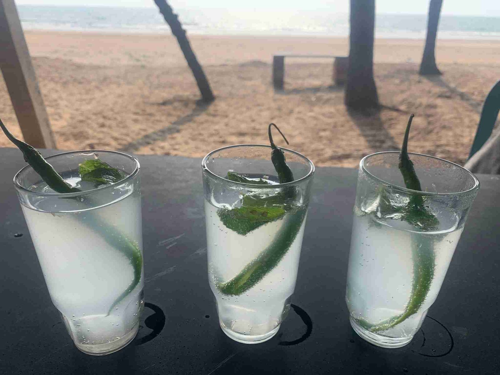 Goan feni drinks with green chili and mint served at beach shack Goa
