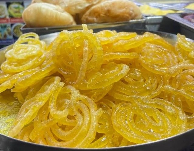 Freshly made golden jalebis soaked in sugar syrup at VV Puram Food Street Bangalore, a popular sweet treat loved by street food enthusiasts.