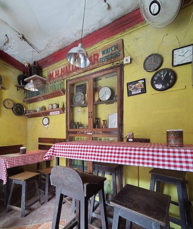 Joseph Bar Goa interior vintage seating wooden stools red checkered tables Panjim