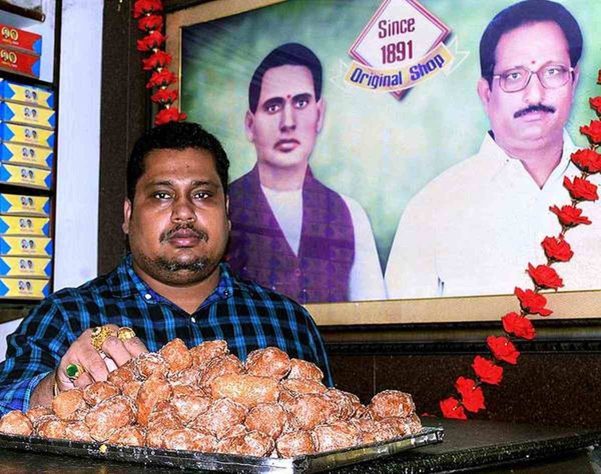 Freshly prepared Kakinada Kaja at Kotaiah’s Sweets with tray full of crispy syrup-coated sweets by fifth-generation member of the family
