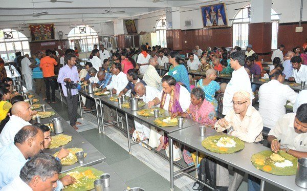 Devotees enjoying free Annaprasadam meal inside the Vengamamba Annadanam dining hall in Tirumala.