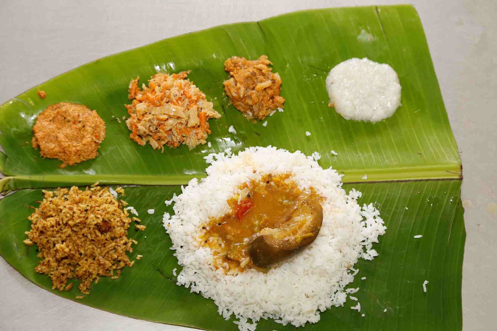 Traditional Tirumala Annaprasadam served on a banana leaf with rice, curry, chutney, and prasadam items.