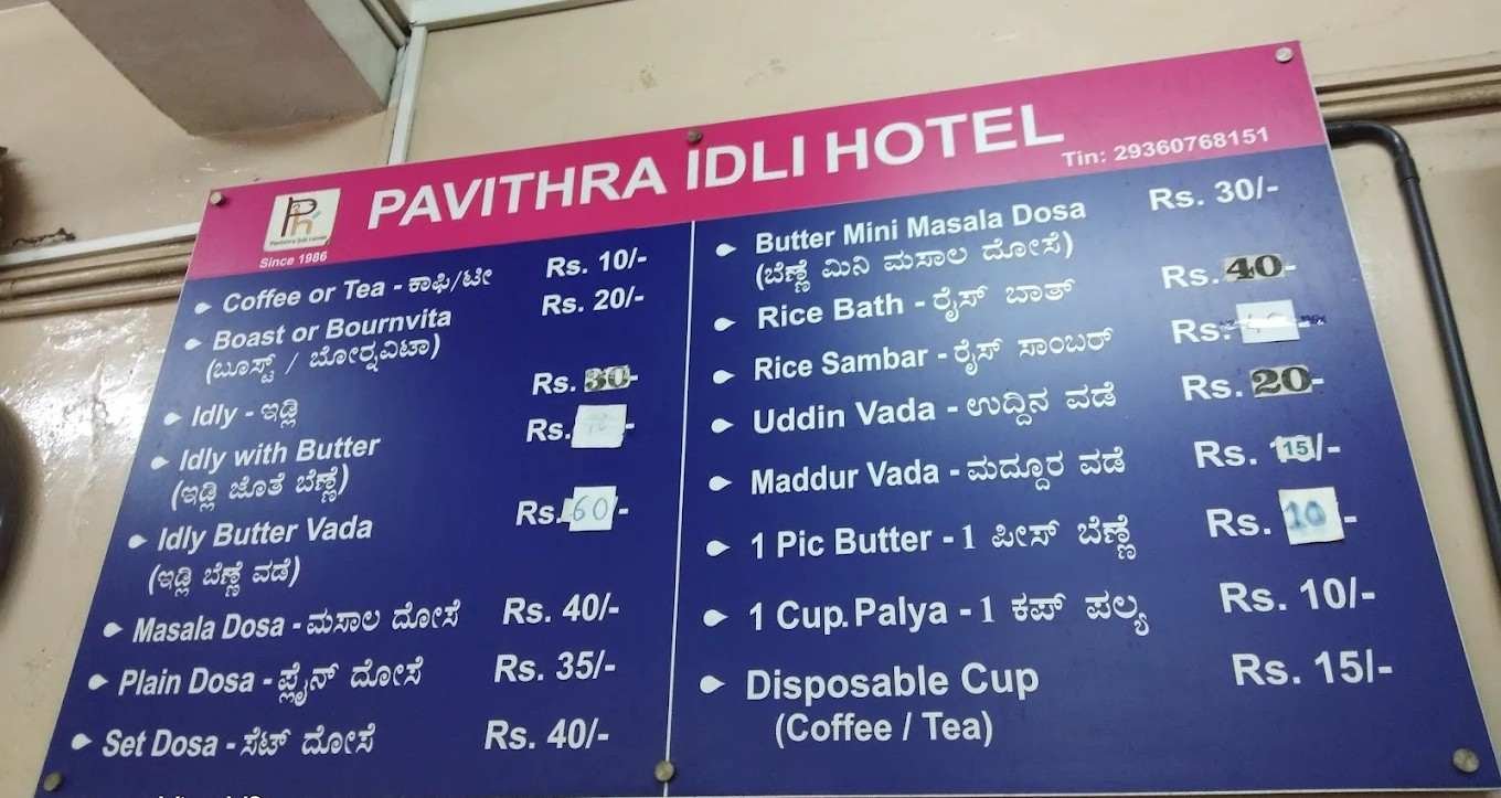 Menu board displaying breakfast items and prices at Pavithra Idli Hotel, Tumakuru.
