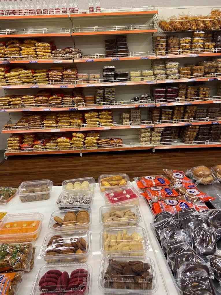 Shelves filled with bakery snacks, biscuits, sweets, and traditional treats inside Sri Srinivasa Brahmins Bakery.