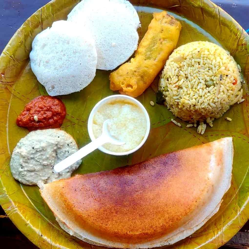 South Indian breakfast platter featuring Mulbagal Dosa, thatte idli, bajji, chitranna, coconut chutney, and red chutney.
