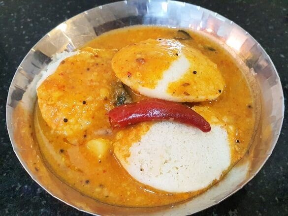Authentic Udupi-style sambar served with soft idlis, a classic South Indian breakfast from Karnataka.